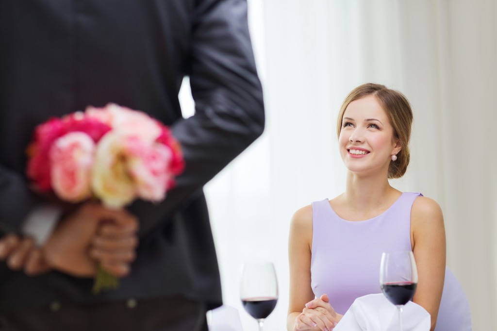 young woman looking at man with flower bouquet