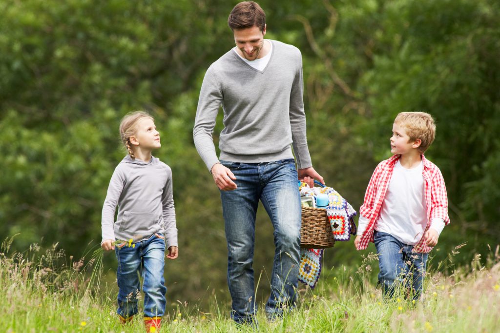 Father Taking Children On Picnic In Countryside