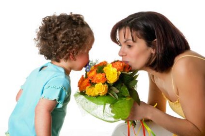 Toddler girl giving flowers to her mom on mother's day
